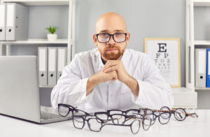 Serious Image Of Male Ophthalmologist In Hospital Office.