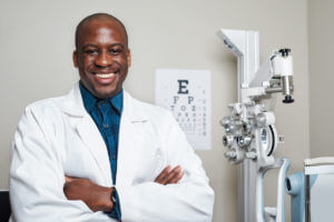 Confident Optometrist in White Coat Smiling in Modern Office with Eye Examination Equipment.