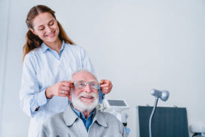A female optometrist helping her mature male patient choose glasses after an eye exam.