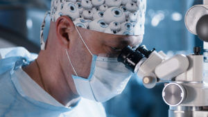 A male cataract surgeon performs a high-precision operation.