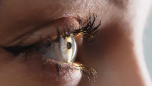 Close-up of a young woman having her vision tested on an ophthalmology diagnostic vision testing equipment.